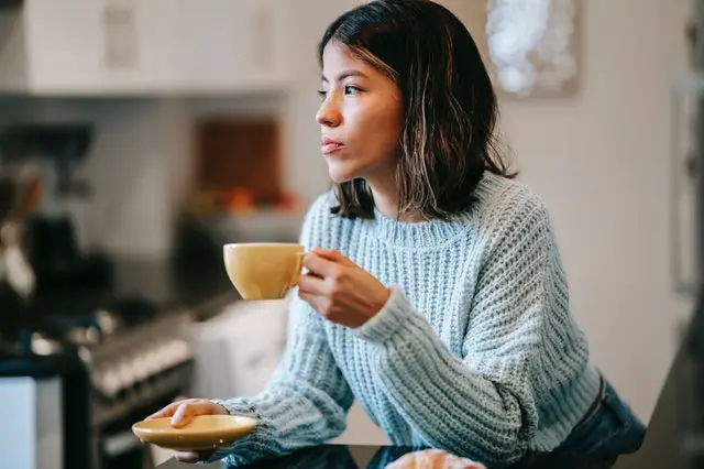 Lady drinking tea holding a saucer